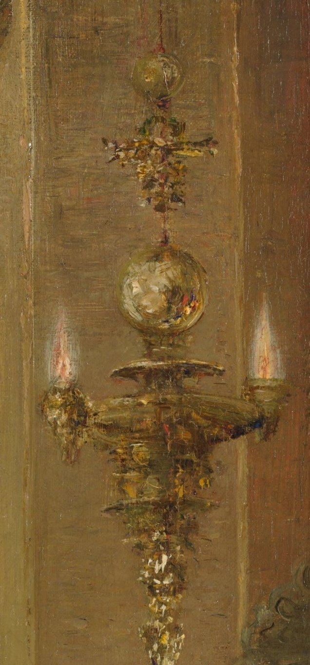 An ornate golden hanging lamp with two lit candles and a glass globe