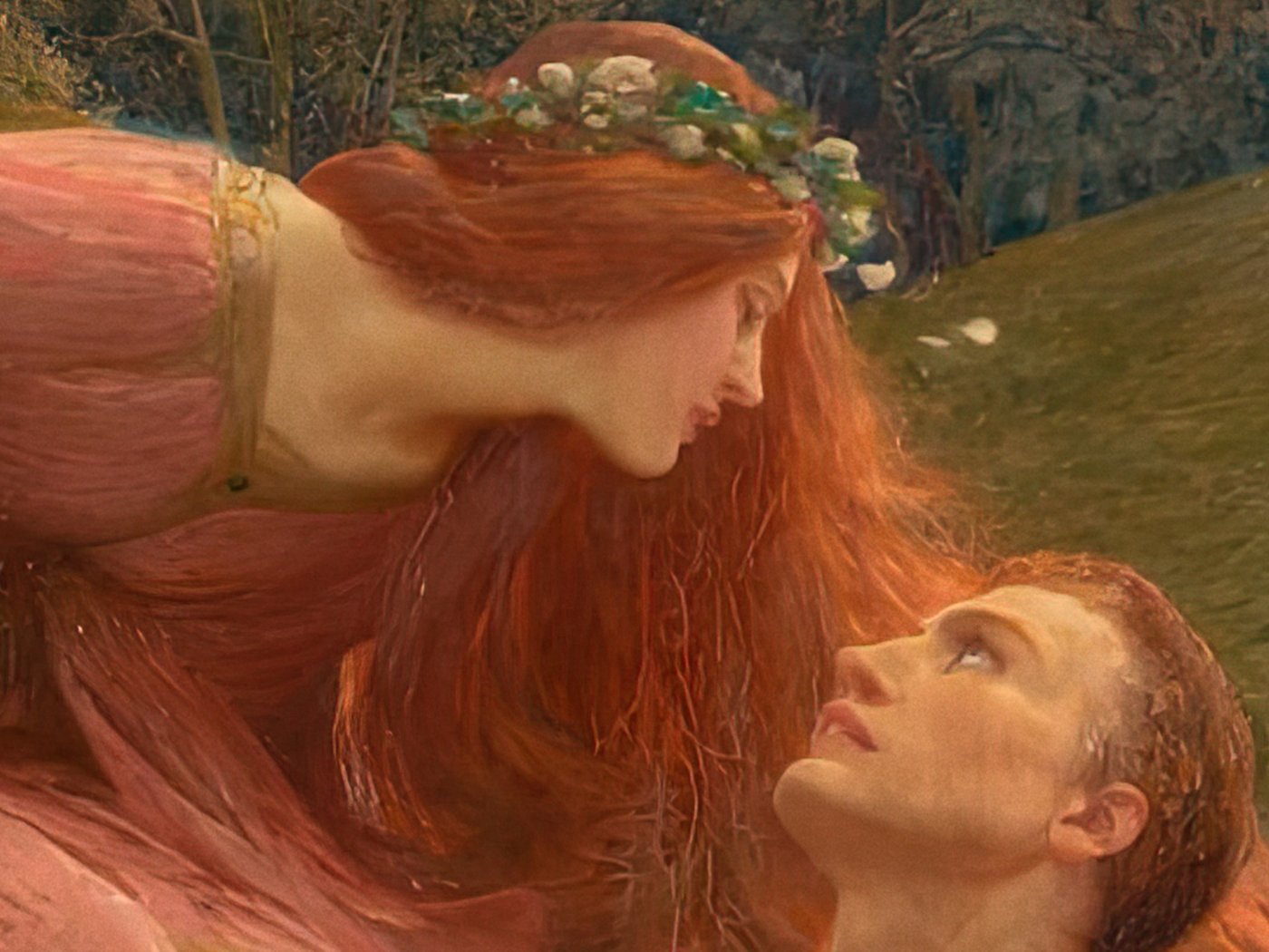 The fairy lady with red hair and a flower garland leaning down toward the upturned face of the knight