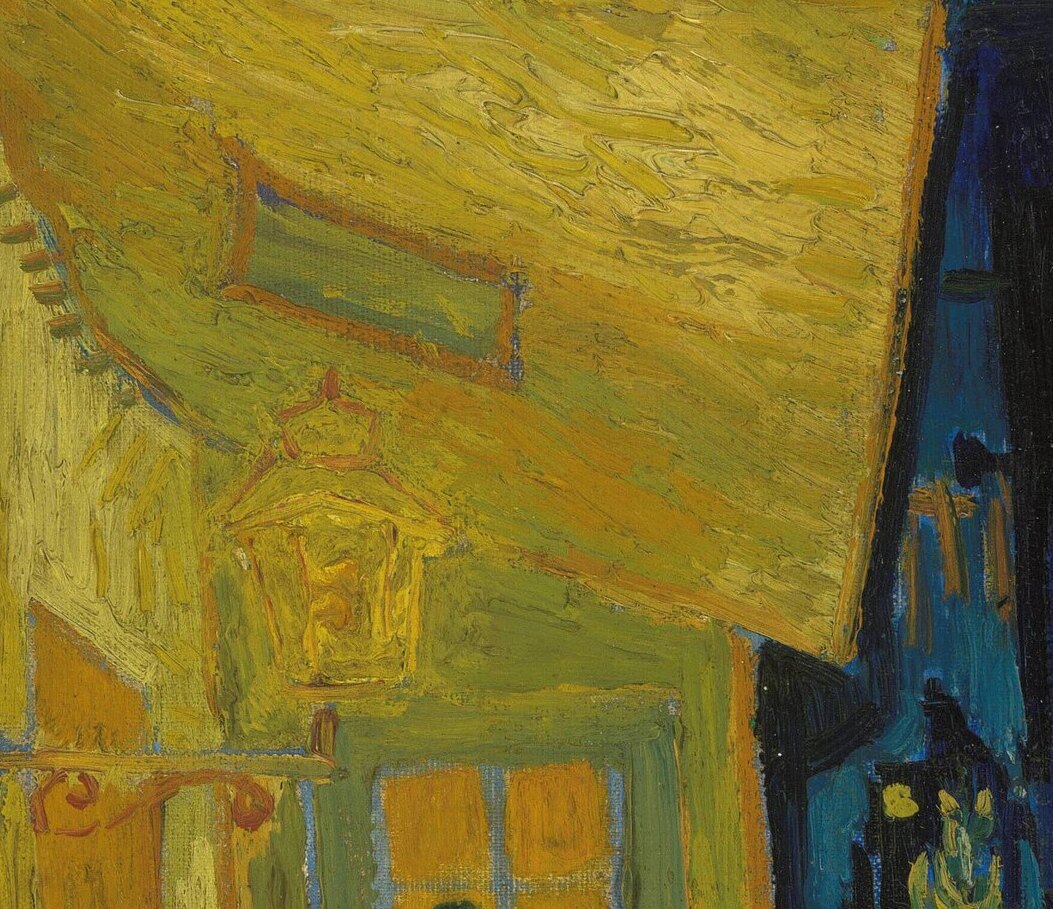 The gas lamp hanging under the awning, glowing yellow against the wall
