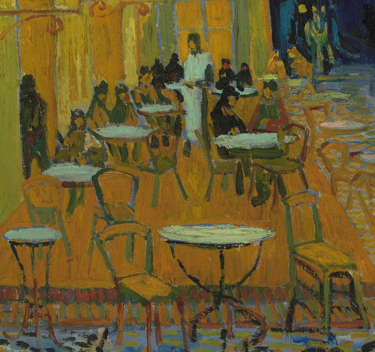 The café terrace under the yellow awning: round tables, chairs, a waiter in white and customers seated