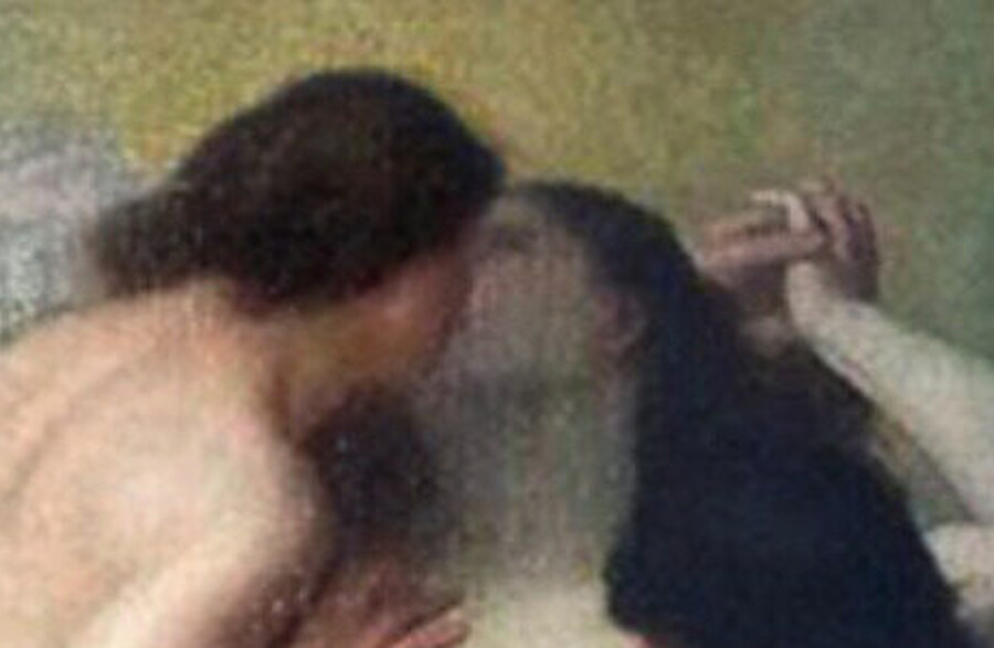 Two women kissing beneath a glow of gold light, the dark-haired one seen from behind
