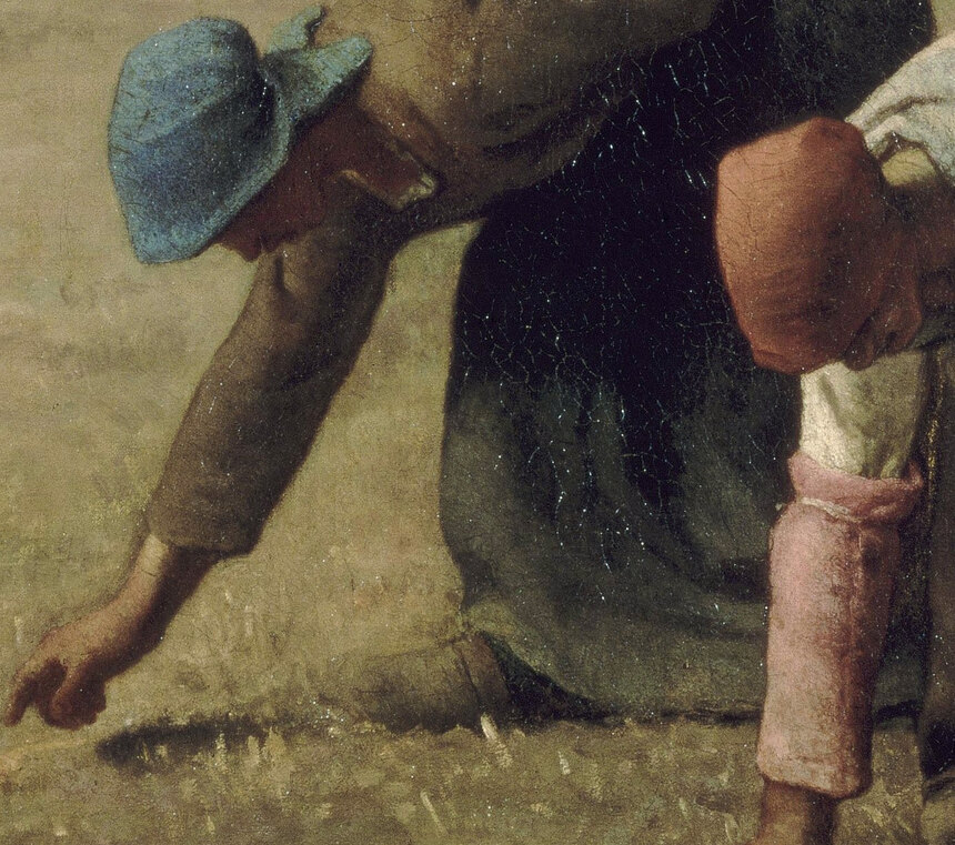 Two women in headscarves bent double, picking single ears of wheat from the stubble