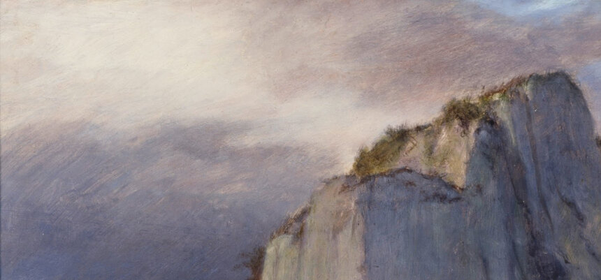The stormy grey and violet sky above the island, with a break of light