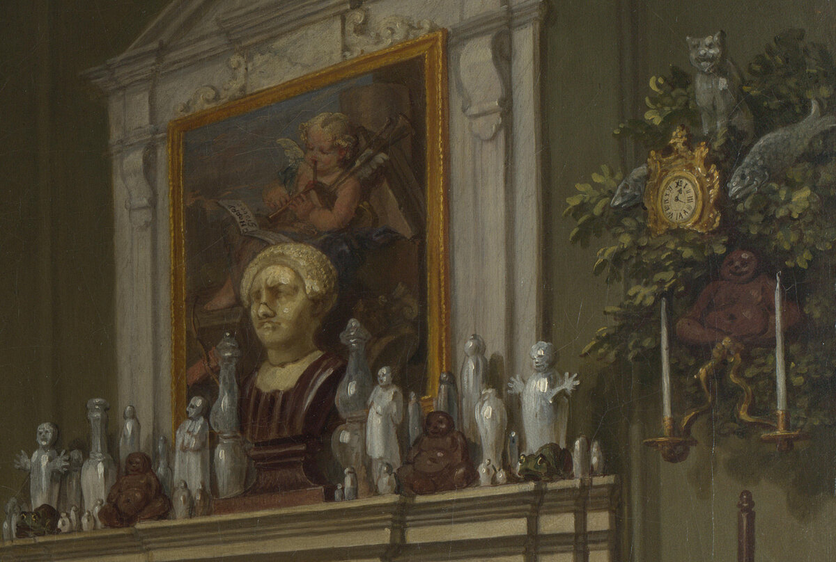 The mantelpiece crowded with china figures and a bust with a broken nose, a painting of Cupid among ruins above it, a rococo clock with a cat and a fish on the wall