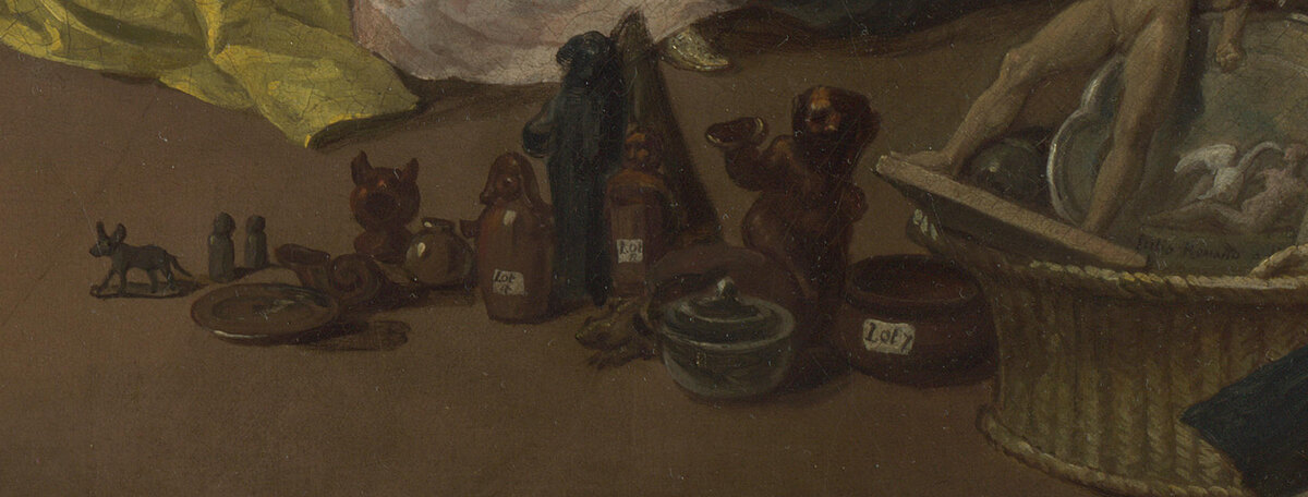 Objects on the floor from an auction: a china figure of Actaeon, a tray, ornaments, a basket, a catalogue
