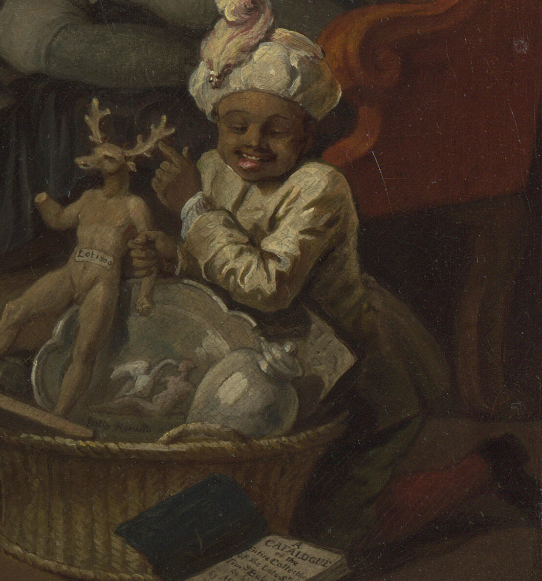 A young black page boy in a turban laughing and pointing at a small figure of Actaeon with stag's antlers on his head