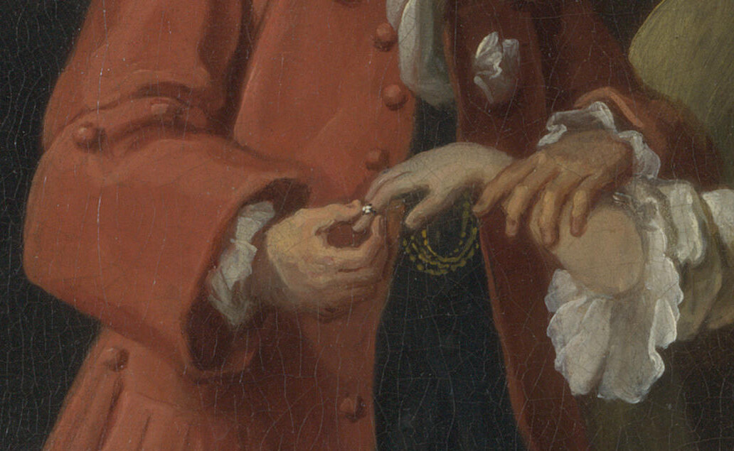Close view of the Alderman's hands pulling the gold ring from his dying daughter's finger