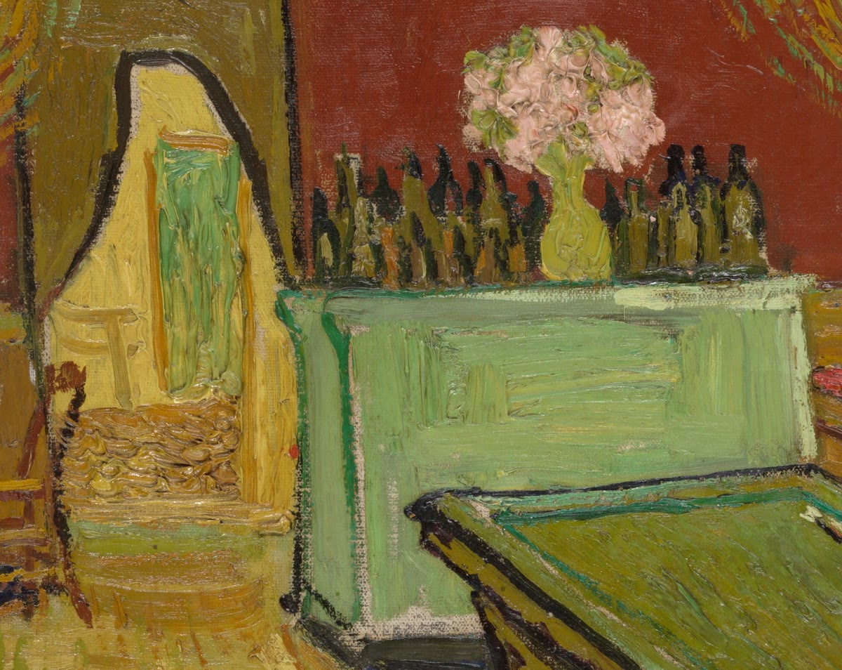 The bar with a row of bottles and a vase of pink flowers, beside a curtained doorway into the back of the house
