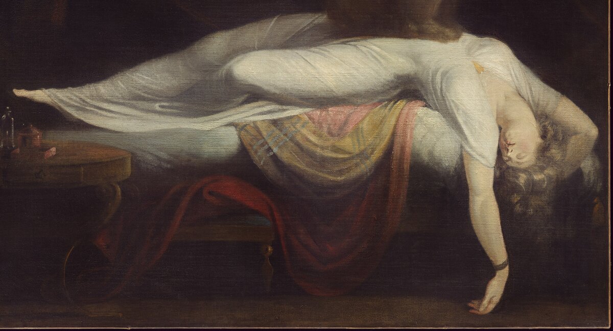 The sleeping woman stretched across the bed in a white gown, head and arm hanging over the edge