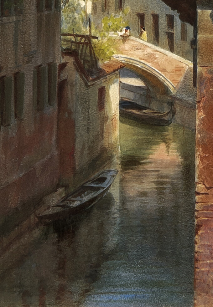 The narrow canal below with a moored boat, a stone bridge and green trees
