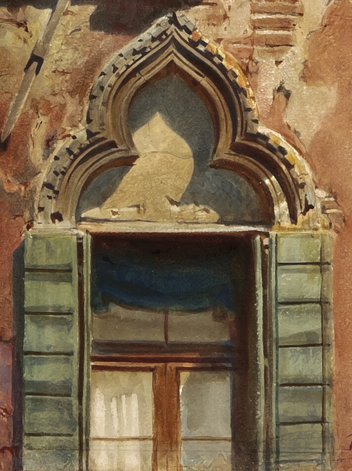 A pointed Gothic window with green wooden shutters and white curtains set in the brick wall below the balcony