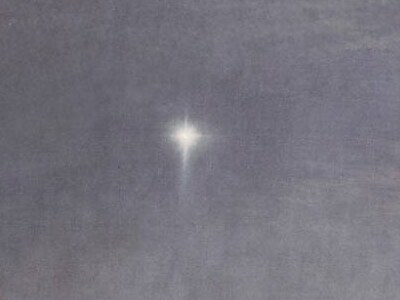 A single bright star shining in the grey sky at dawn