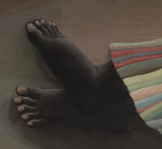 The sleeper's bare feet and the wooden staff resting in her hand on the sand