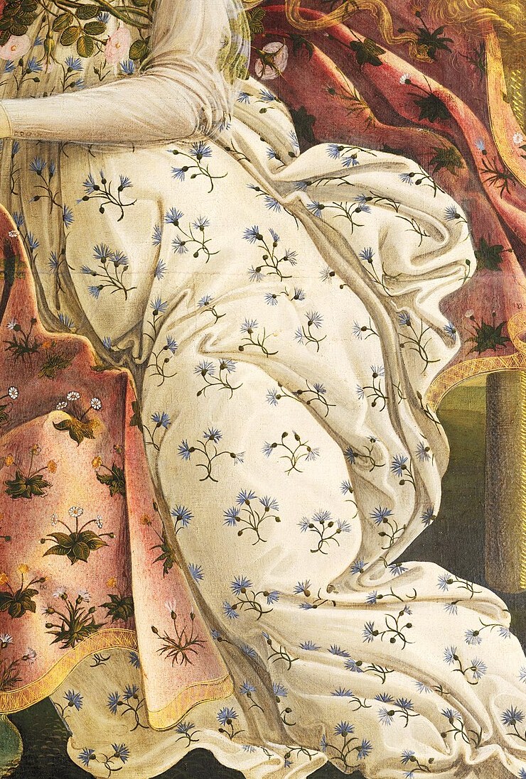 The Hora's white dress embroidered with blue cornflowers, a garland of myrtle at her neck and roses at her waist