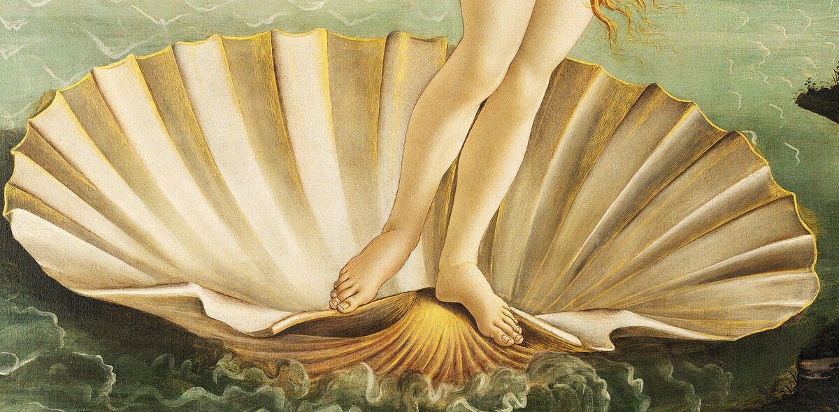 The large scallop shell at the water's edge with Venus's feet on it