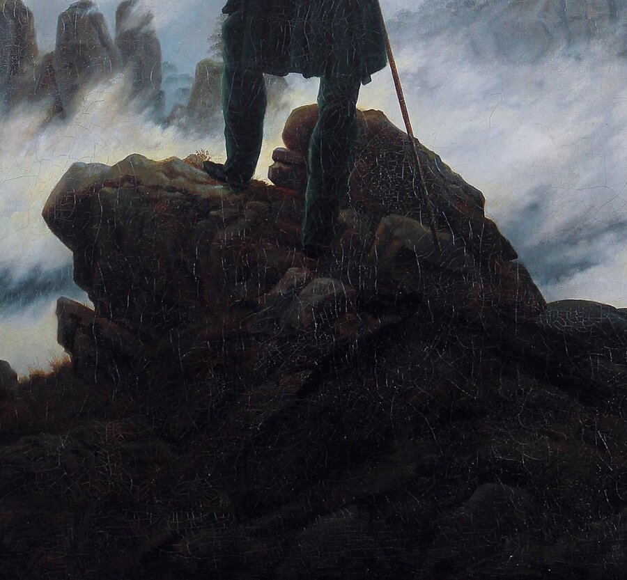 The dark rock summit and the tip of the cane against the fog