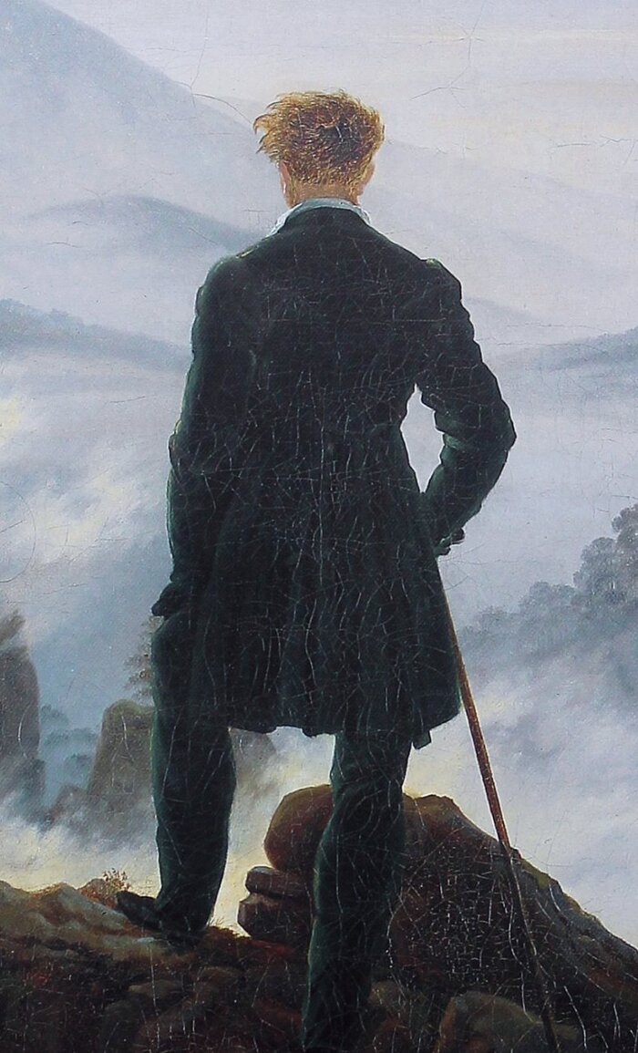 The wanderer seen from behind, one foot forward, cane in hand