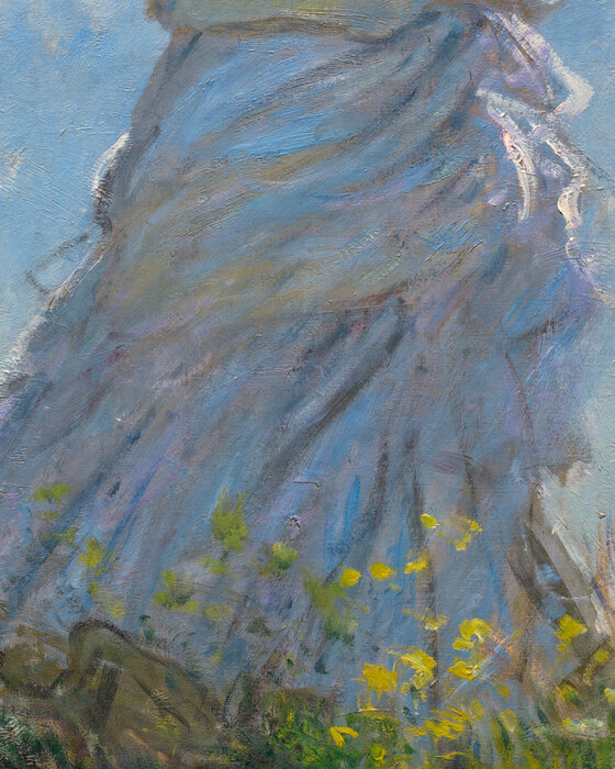 The white dress blown sideways, reflecting the blue of the sky and the green of the grass