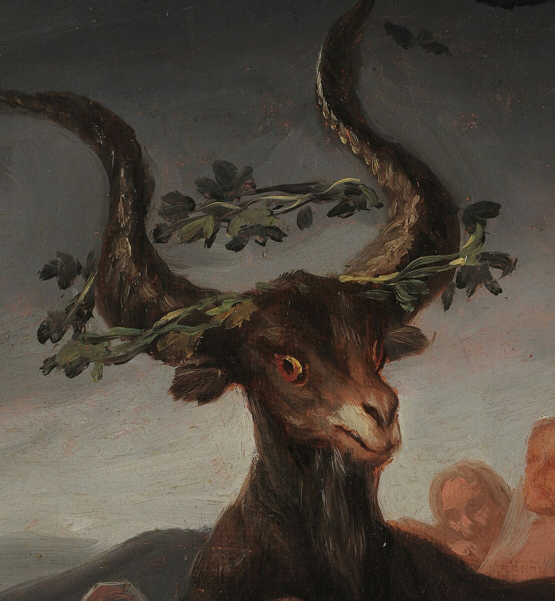 The head of the great black goat with a wreath of vine leaves in its horns, eyes turned toward the witches