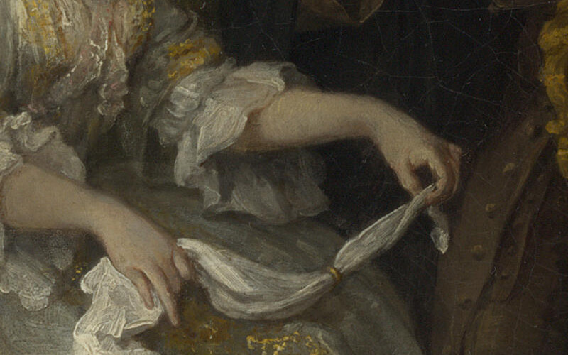 The bride's hands sliding her ring along a white handkerchief