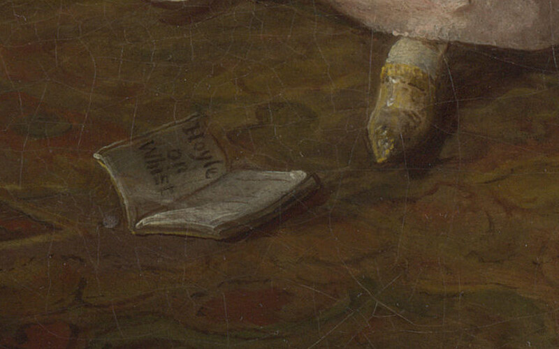 A small book about card playing lying open on the carpet