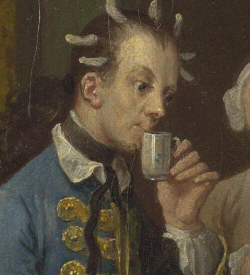 A young man with curl papers in his hair sipping chocolate