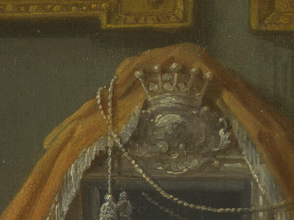A silver coronet on top of the dressing-table mirror