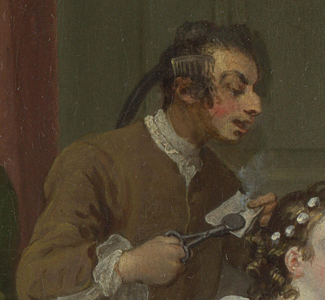 The hairdresser testing his curling tongs on a scrap of paper