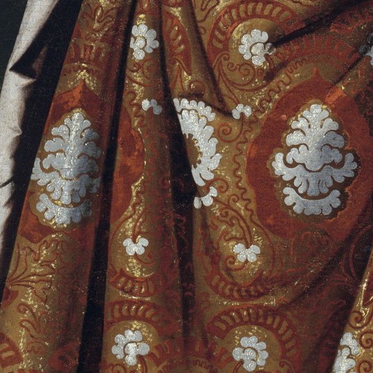 Close-up of Saint Casilda's red and gold brocade skirt with large silver-white flower motifs