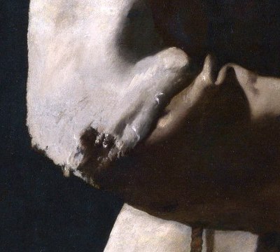 A torn and patched sleeve of Saint Francis's habit, pale against the brown cloth