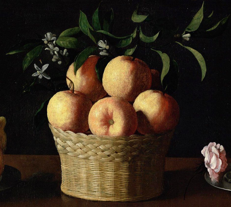 A wicker basket of oranges crowned with green leaves and white orange blossom