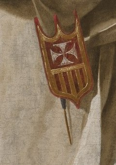 The red and gold badge of the Order of Mercy pinned to the white habit